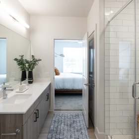 a bathroom with a shower, sink and a mirror
